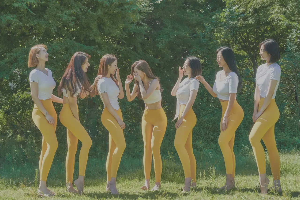 노란 레깅스를 입은 강사들이 숲 앞에서 웃으며 이야기하는 모습